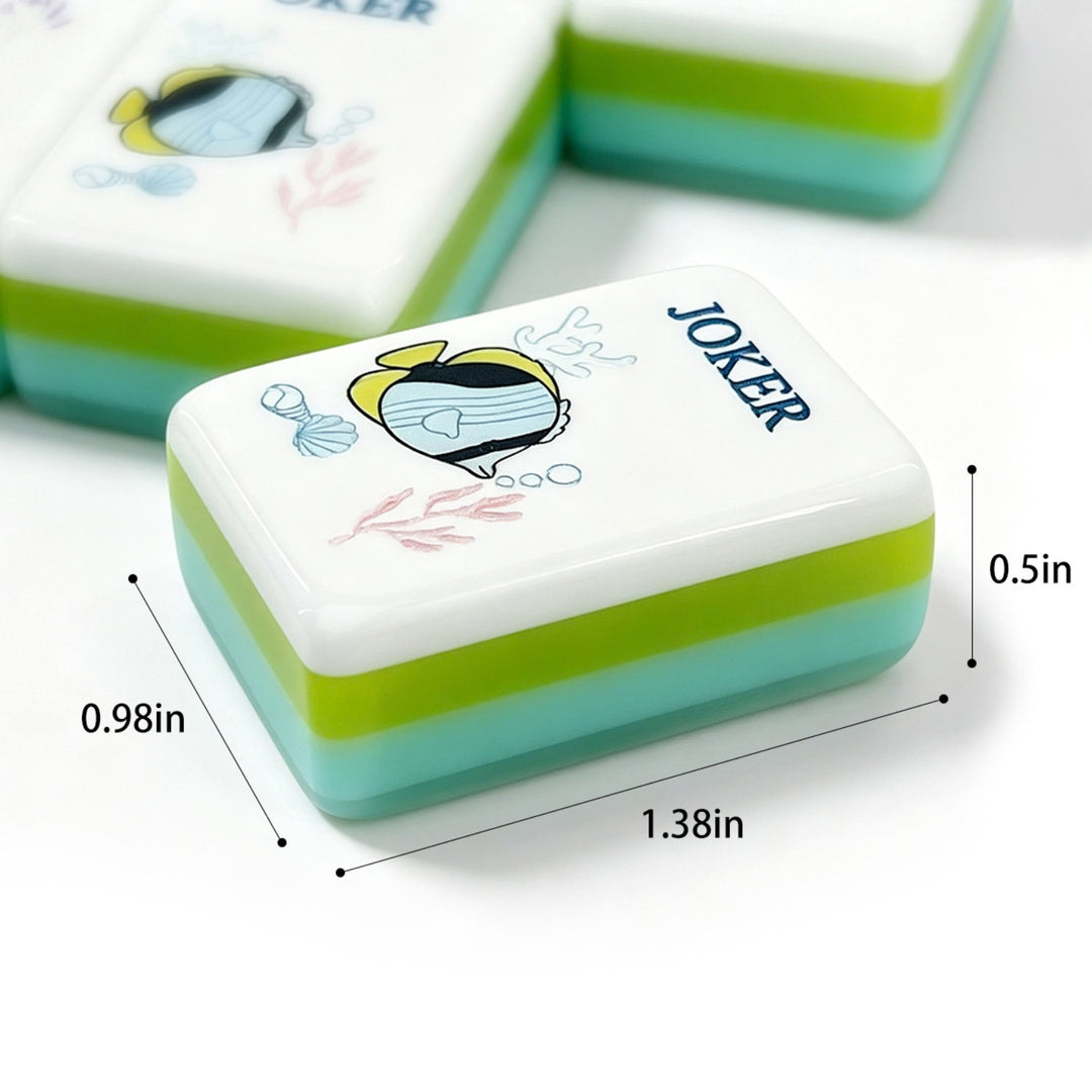 Close-up view and dimensions diagram (1.38 x 0.98 x 0.5 in) of a single large-size acrylic tile featuring a tropical fish Joker and multi-layer green and blue back for the Coastal Ocean American Mahjong set.