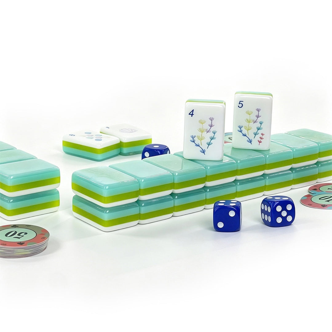 Stacked tile wall and game setup for the large-size Coastal Ocean American Mahjong set from the Artistry Collection by The Mahjong Tile, showing multi-layer blue-green acrylic edges, dice, and chips.